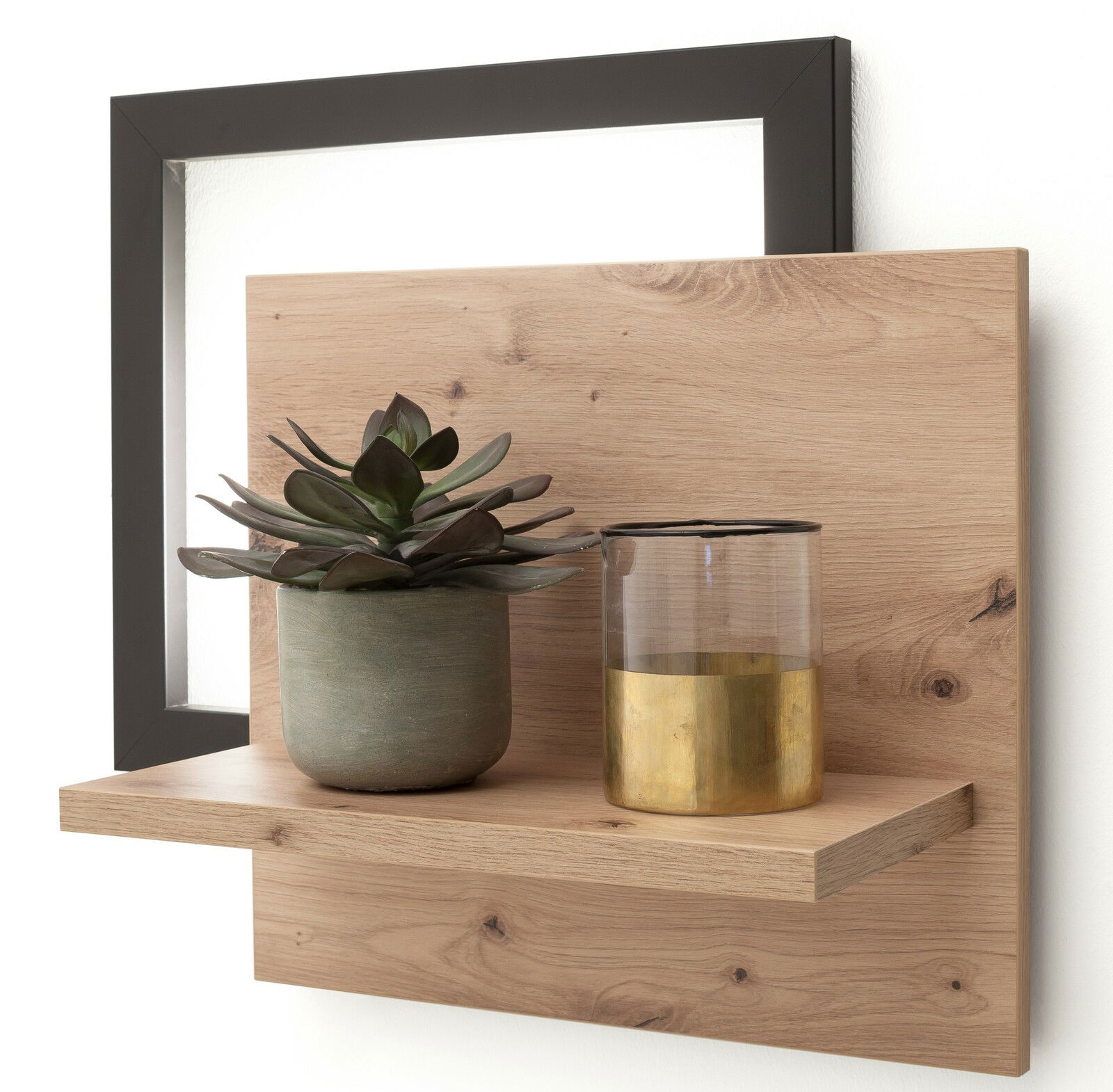 Wandboard aus Holz mit schwarzem Rahmen, dekoriert mit einer Pflanze im Topf und einem Glas mit goldener Verzierung, seitliche Perspektive
