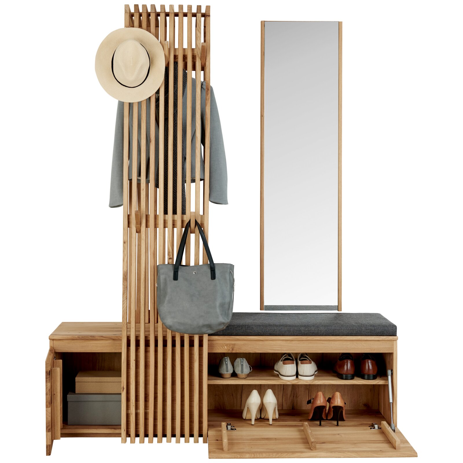 Garderoben-Set aus hellem Holz mit Lamellenpaneel, Sitzbank mit Schuhfächern und großem Standspiegel, frontal in leichter Schrägansicht fotografiert; Hut, Jacke und Tasche hängen an der Garderobe, Schuhe sind in den Fächern verstaut.