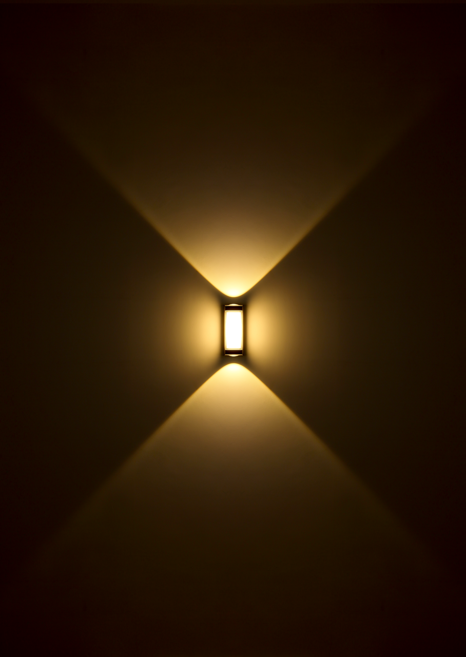 LED-Außenwandleuchte mit warmem Licht, das in einem symmetrischen Muster nach oben und unten strahlt, frontale Ansicht.