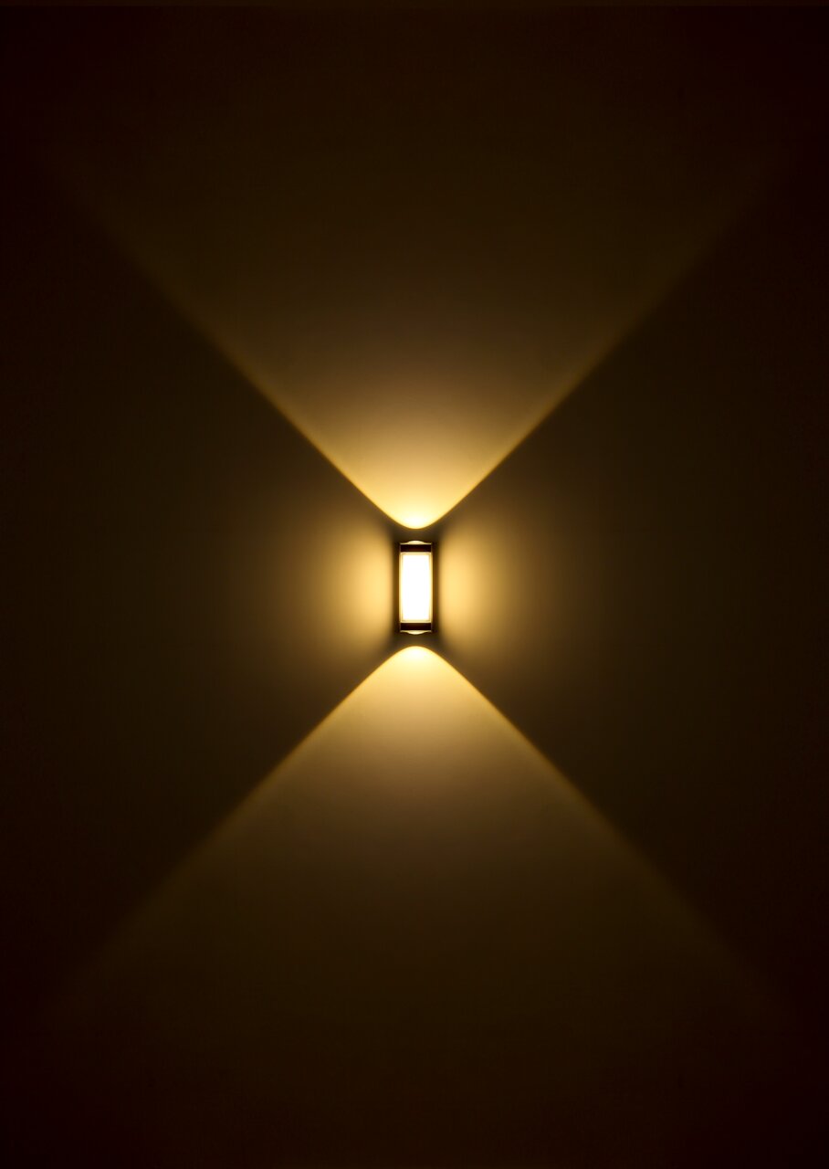 LED-Außenwandleuchte mit warmem Licht, das in einem symmetrischen Muster nach oben und unten strahlt, frontale Ansicht.