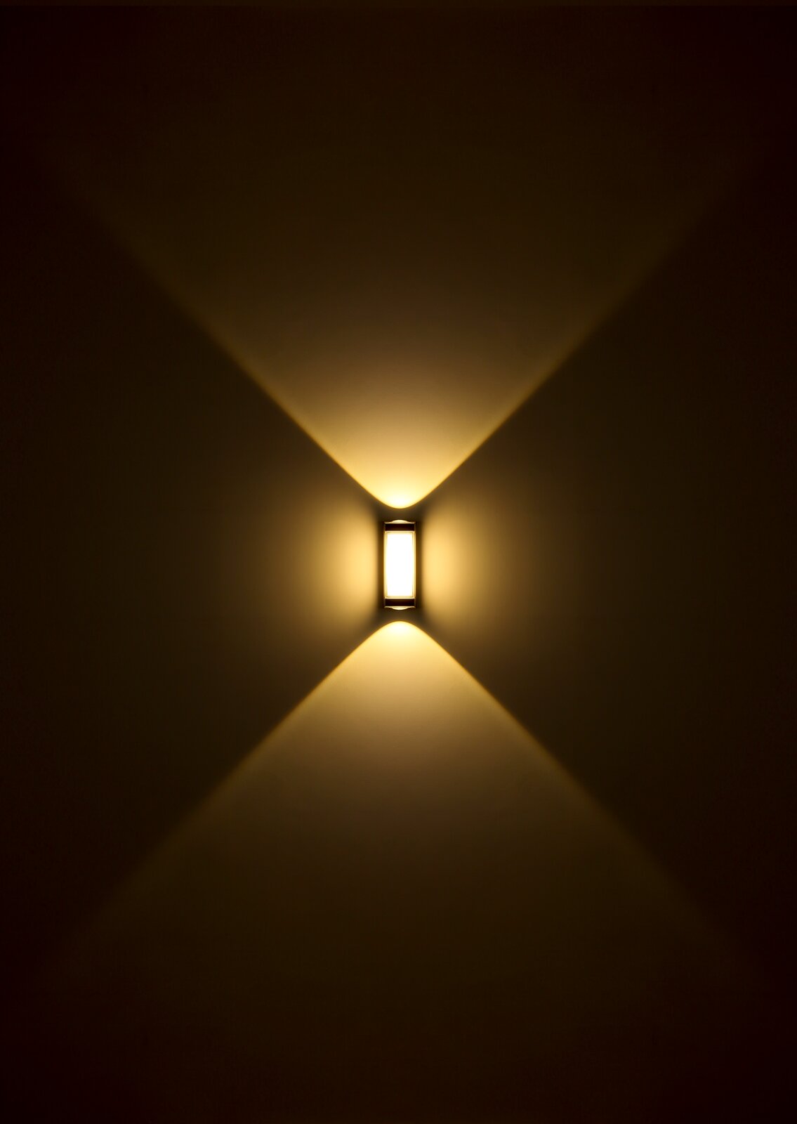 LED-buitenwandlamp met warm licht dat in een symmetrisch patroon naar boven en beneden schijnt, vooraanzicht.