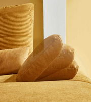 Nahaufnahme einer gelben Rundecke mit weichem Stoffbezug, seitliche Perspektive