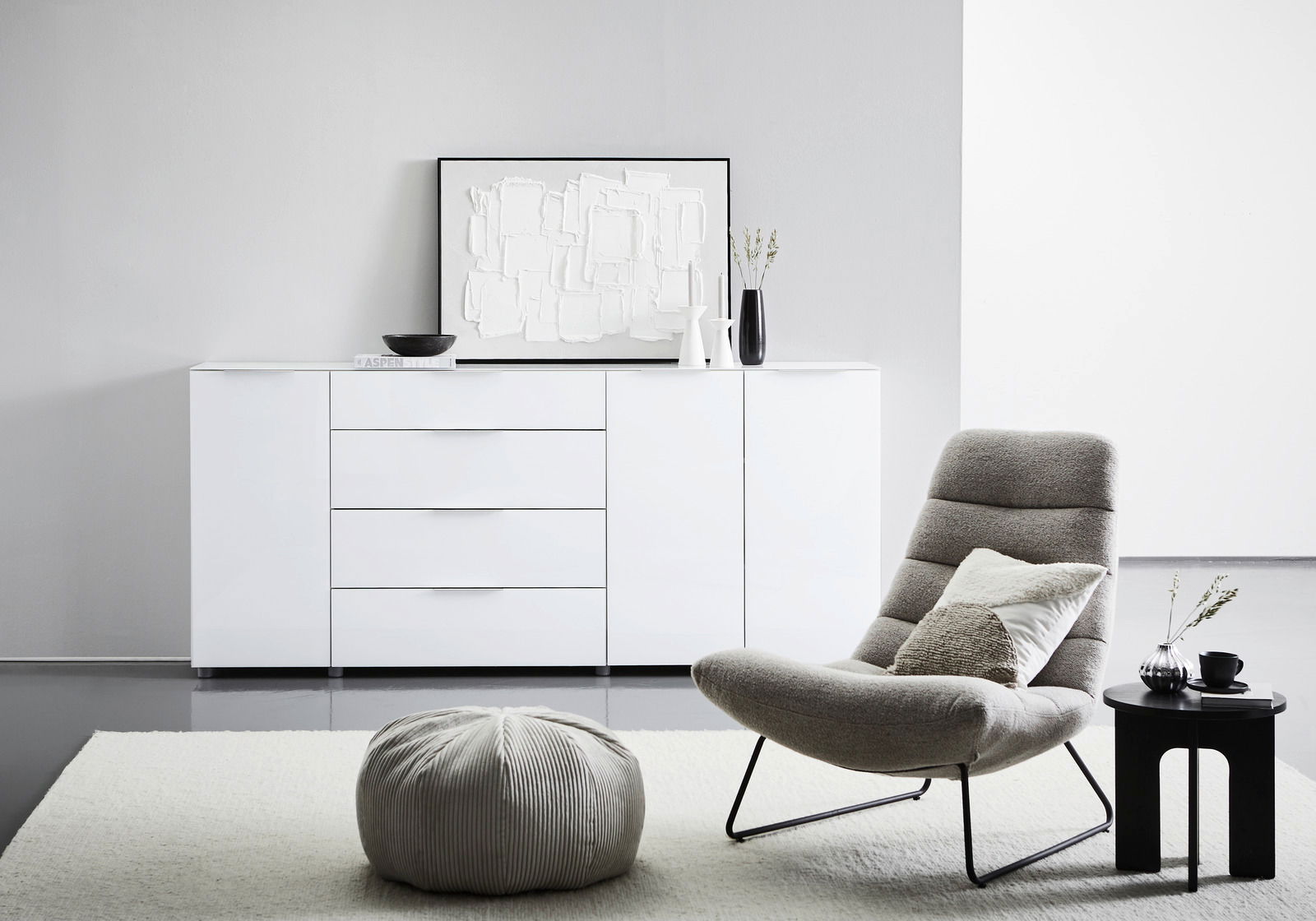 Modernes weißes XL-Sideboard mit Hochglanzoberfläche, frontal abgebildet in einem stilvollen Wohnzimmer mit dekorativen Elementen.