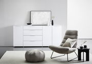 Modernes weißes XL-Sideboard mit Hochglanzoberfläche, frontal abgebildet in einem stilvollen Wohnzimmer mit dekorativen Elementen.