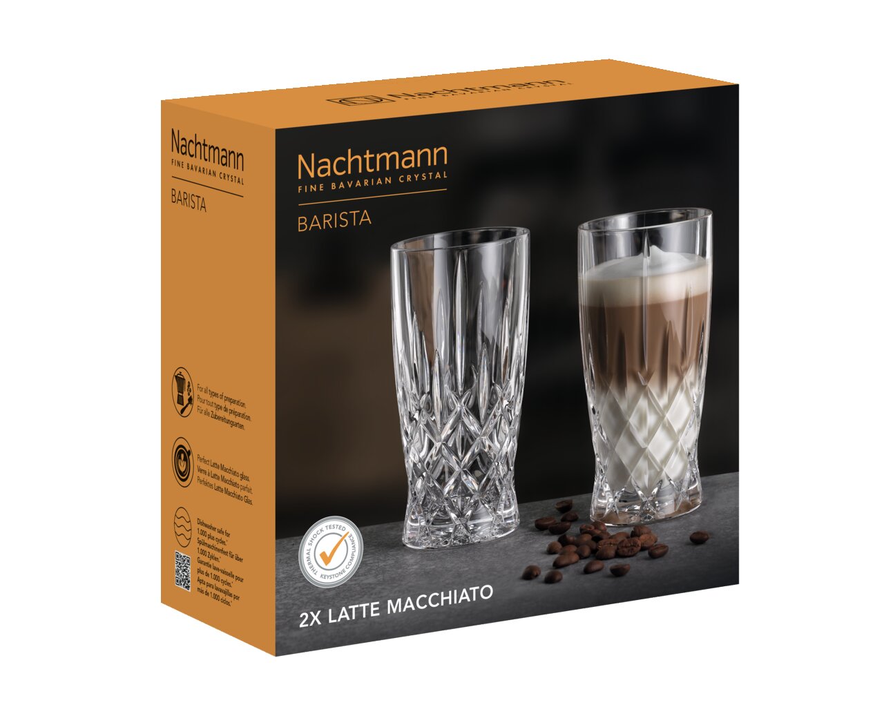 Verpakking van de Barista Latte Macchiato SET/2 van Nachtmann met twee kristallen glazen, één leeg en één gevuld met latte macchiato, op een donkere ondergrond met koffiebonen, zijaanzicht.