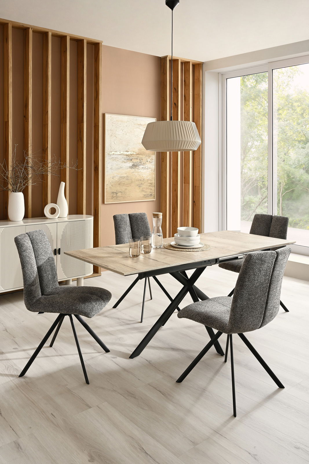 Moderner Esstisch mit Holzplatte und schwarzen Metallbeinen, umgeben von vier grauen Stühlen in einem stilvollen Esszimmer. Seitliche Perspektive.