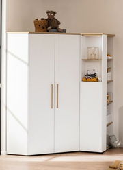 Weißes Eck-Regal mit zwei Türen und offenen Regalfächern, frontal fotografiert. Dekoriert mit Spielzeug und Körben.