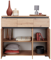 Sideboard aus Holz mit drei Schubladen und offenen Türen, gefüllt mit Dekorationsgegenständen und Textilien, aus der Frontperspektive.