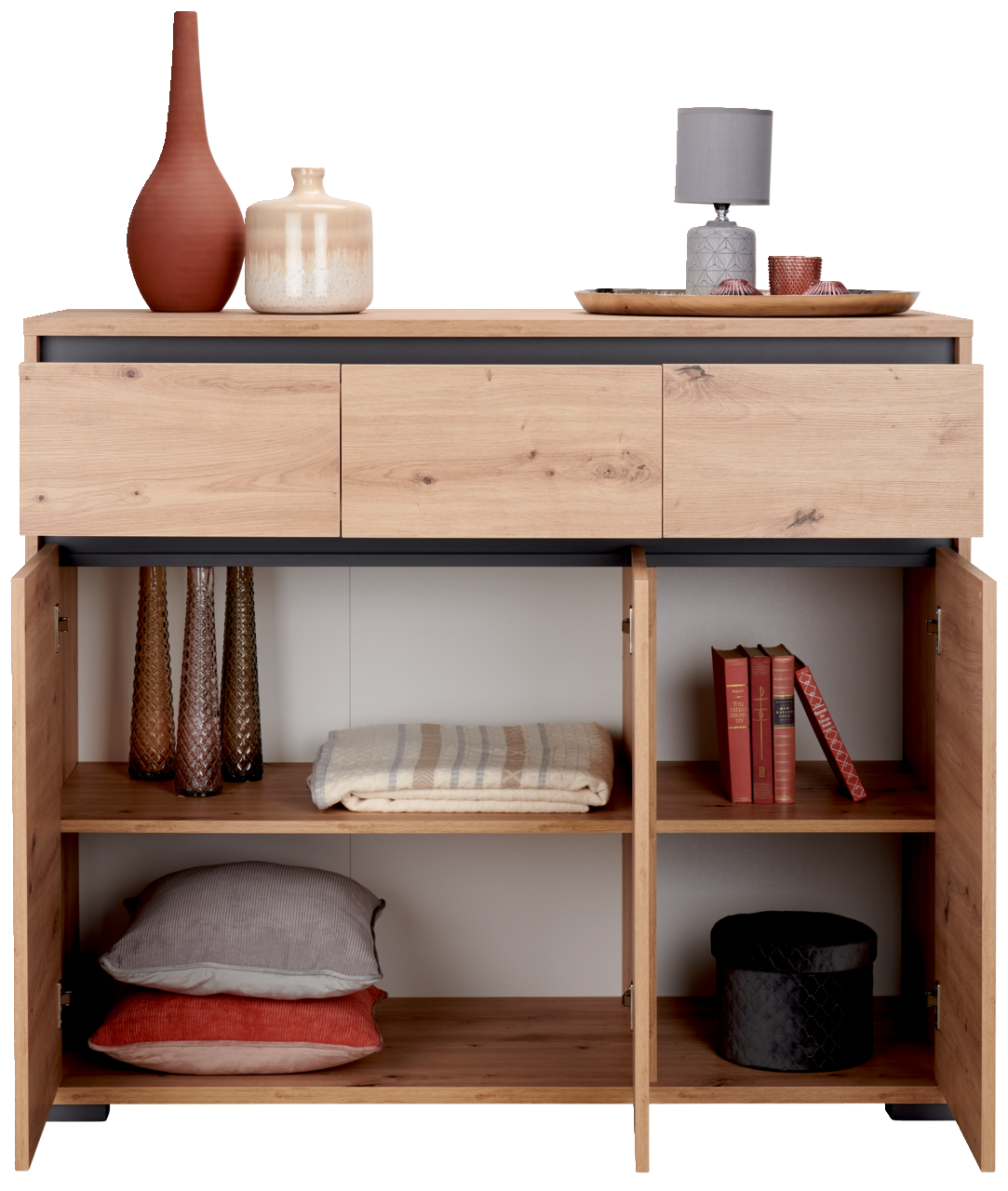 Sideboard aus Holz mit drei Schubladen und offenen Türen, gefüllt mit Dekorationsgegenständen und Textilien, aus der Frontperspektive.