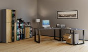 Modernes Büro mit L-förmigem Schreibtisch in Grau/Schwarz, Rollcontainer in Holzoptik, Aktenregalen und Computer; Perspektive: frontale, leicht seitliche Ansicht auf die Arbeitsfläche.