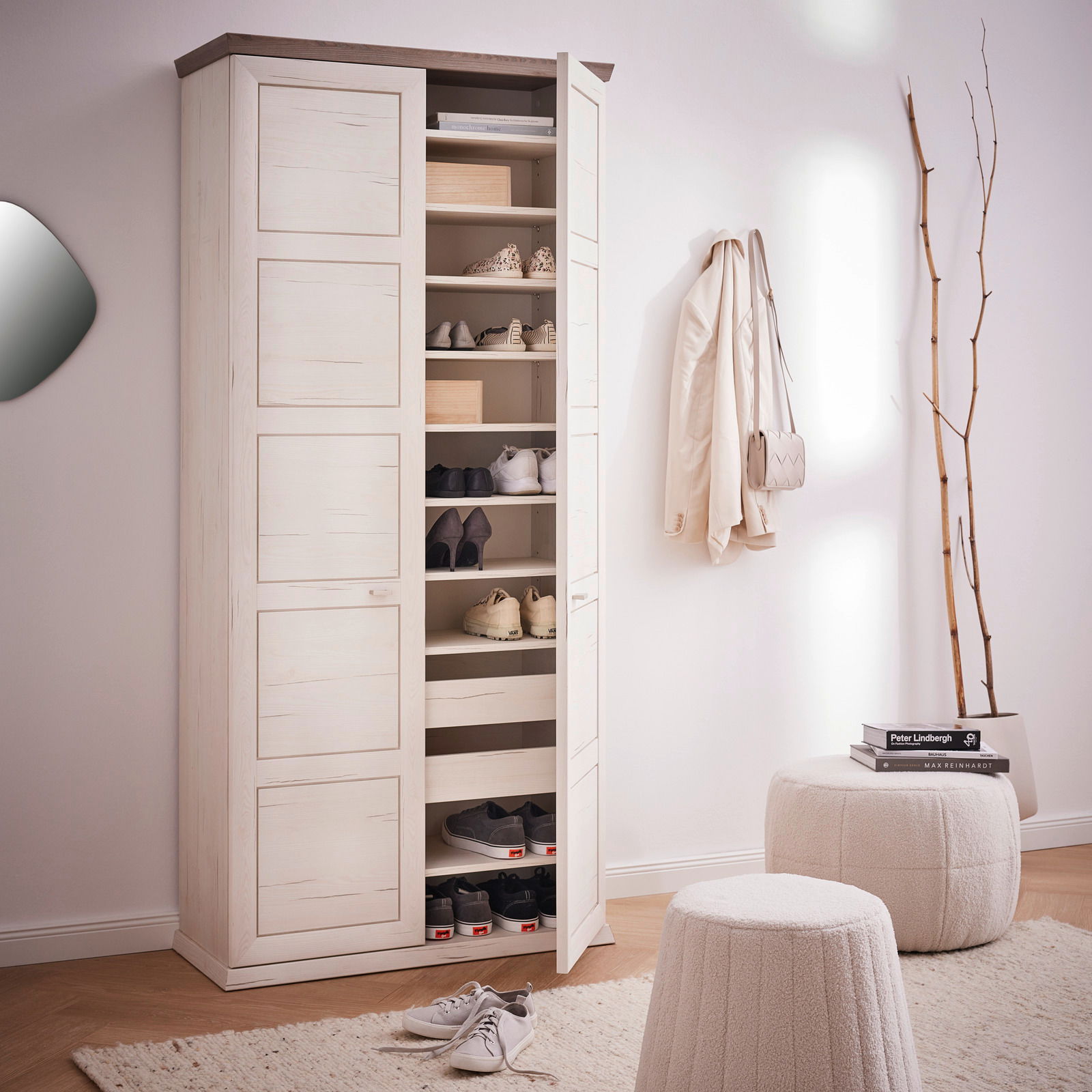 XL-Schuhschrank in heller Holzoptik mit geöffneter Tür, gefüllt mit Schuhen und Boxen, in einem stilvoll eingerichteten Raum. Perspektive von vorne.