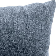 Nahaufnahme eines blauen, texturierten Sofakissens in einer Eckeansicht.