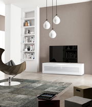 Modernes Wohnzimmer mit TV-Lowboard in Weiß, frontal betrachtet, mit hängenden Lampen und Bücherregal im Hintergrund.