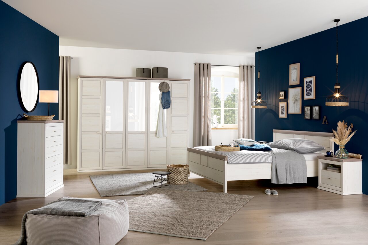 Helles Schlafzimmer mit einem 5-türigen Drehtürenschrank CAMRON, Bett und Kommode in einem modernen, gemütlichen Design. Perspektive: Frontalansicht des Schranks.