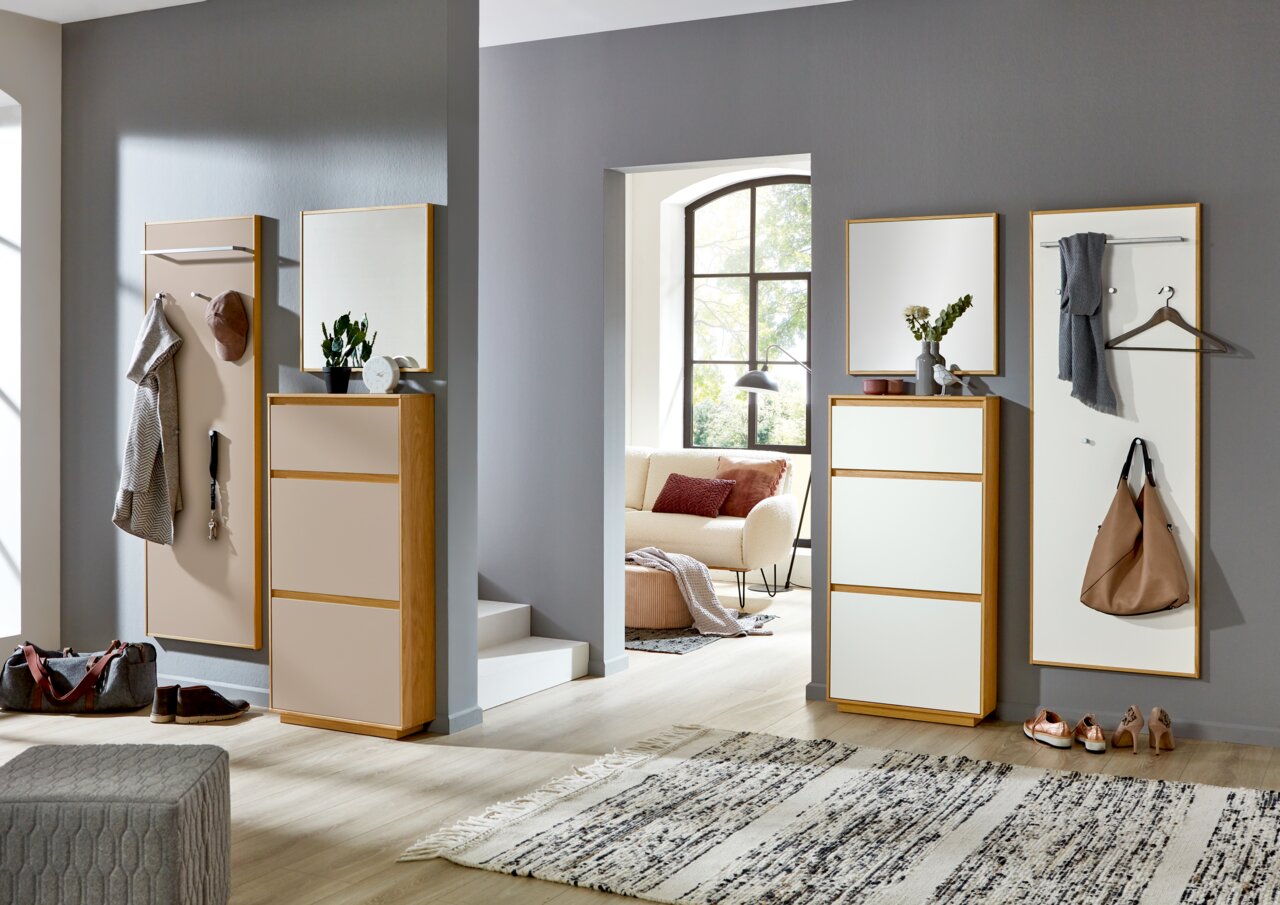 Moderne Garderobeneinrichtung mit Spiegel, Schuhschrank und Garderobenpaneel in einem hellen Raum, seitliche Perspektive.