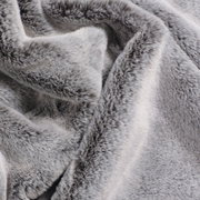 Close-up van een zacht, grijs plaid met een donzige textuur.