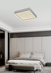 Moderne quadratische LED-Deckenleuchte mit dekorativem Muster, von unten betrachtet in einem stilvollen Schlafzimmer montiert.