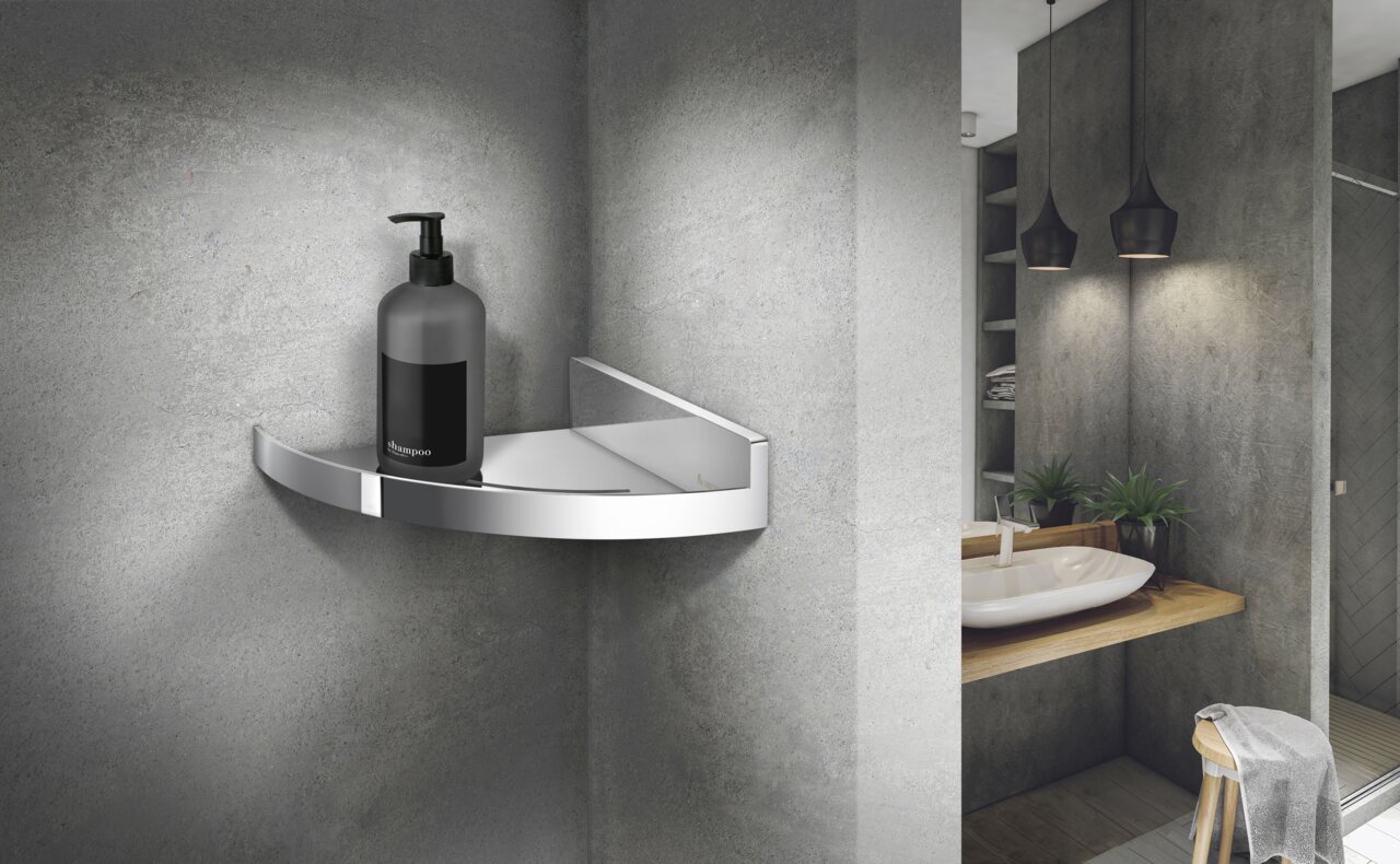 Verchroomd hoekdoucherek van Smedbo in een moderne badkamer, in perspectief gezien vanaf linksvoor, met daarop een shampoofles.