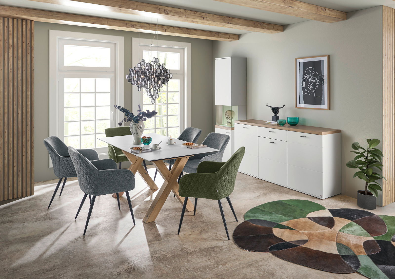 Moderner Esstisch mit Holzkreuzgestell und weißer Tischplatte, umgeben von gepolsterten Stühlen in einem stilvollen Esszimmer mit Blick auf große Fenster.