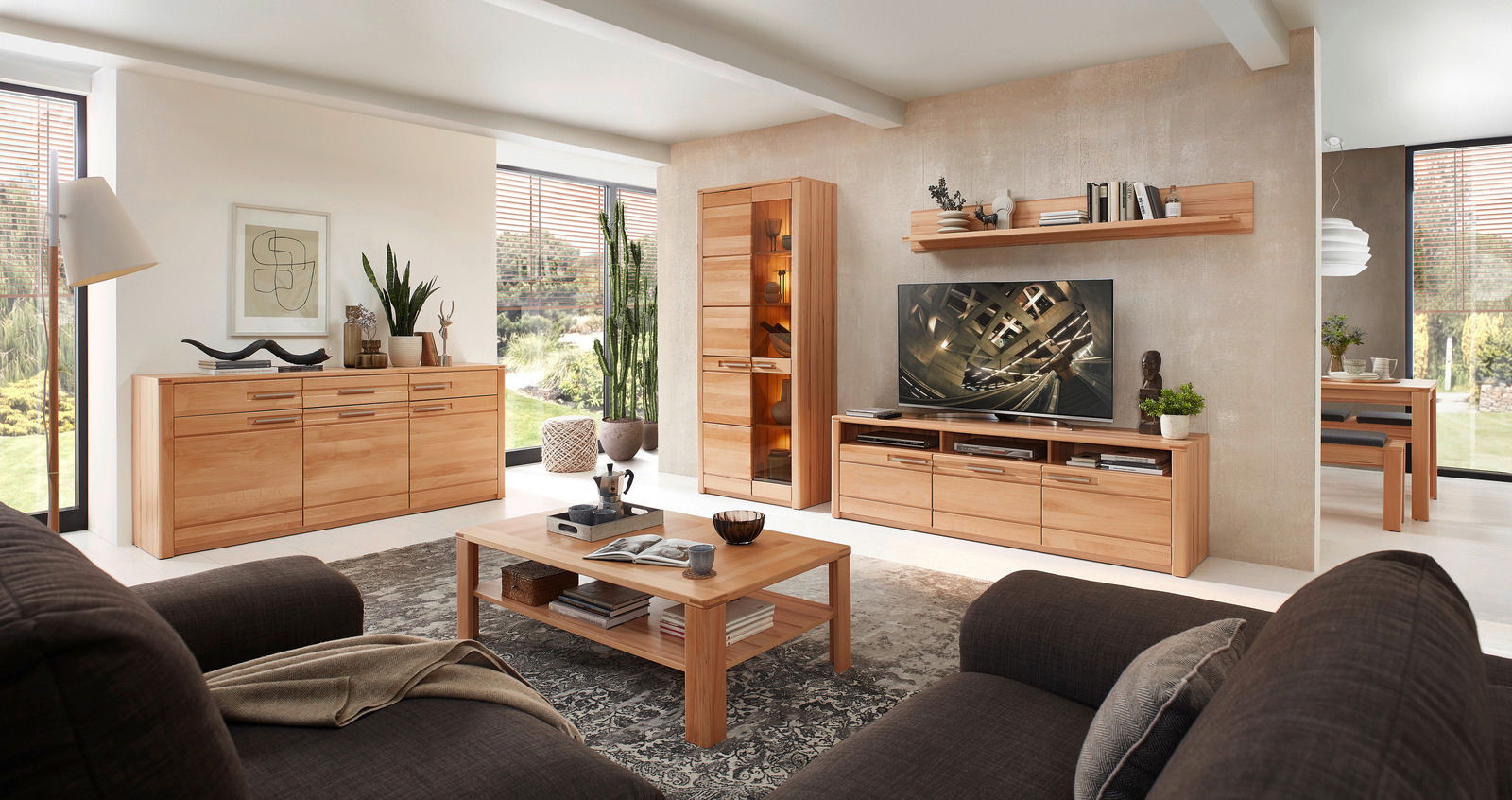 Wohnzimmer mit modernen Holzmöbeln, darunter ein TV-Lowboard, ein Couchtisch und ein Sideboard, aus der Perspektive von einem Sofa aus gesehen.