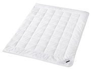 Weiße Faserdecke Uno in schräger Draufsicht, mit gestepptem Muster und Etikett in der Ecke.