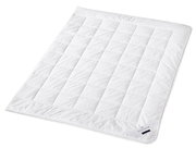 Weiße Faserdecke Uno in schräger Draufsicht, mit gestepptem Muster und Etikett in der Ecke.