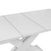 Nahaufnahme eines weißen Funktions-Esstisches mit erweiterbarer Tischplatte und modernem X-förmigem Gestell, von oben betrachtet.