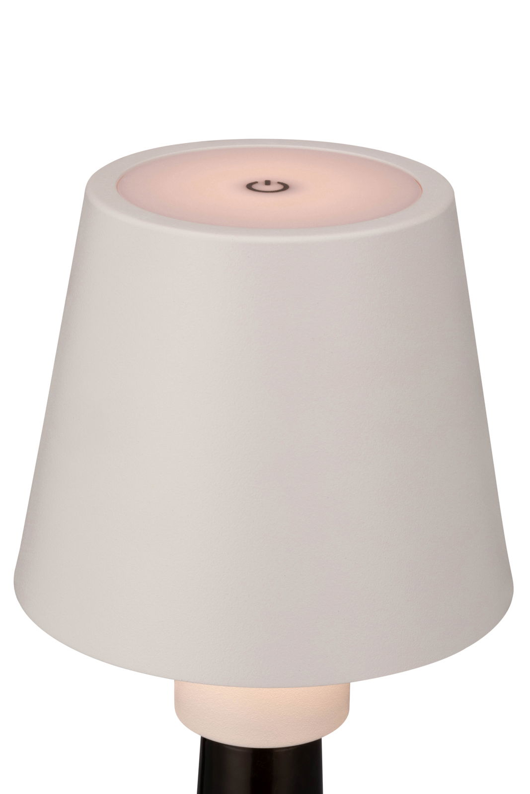 Nahaufnahme einer weißen Akku-Tischleuchte mit einem runden, leicht rosa leuchtenden Schalter auf der Oberseite, aus seitlicher Perspektive.
