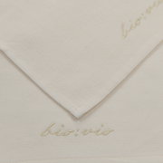 Nahaufnahme eines weißen Gästetuchsets mit dezenter Stickerei 'bio:vio' in der Ecke.