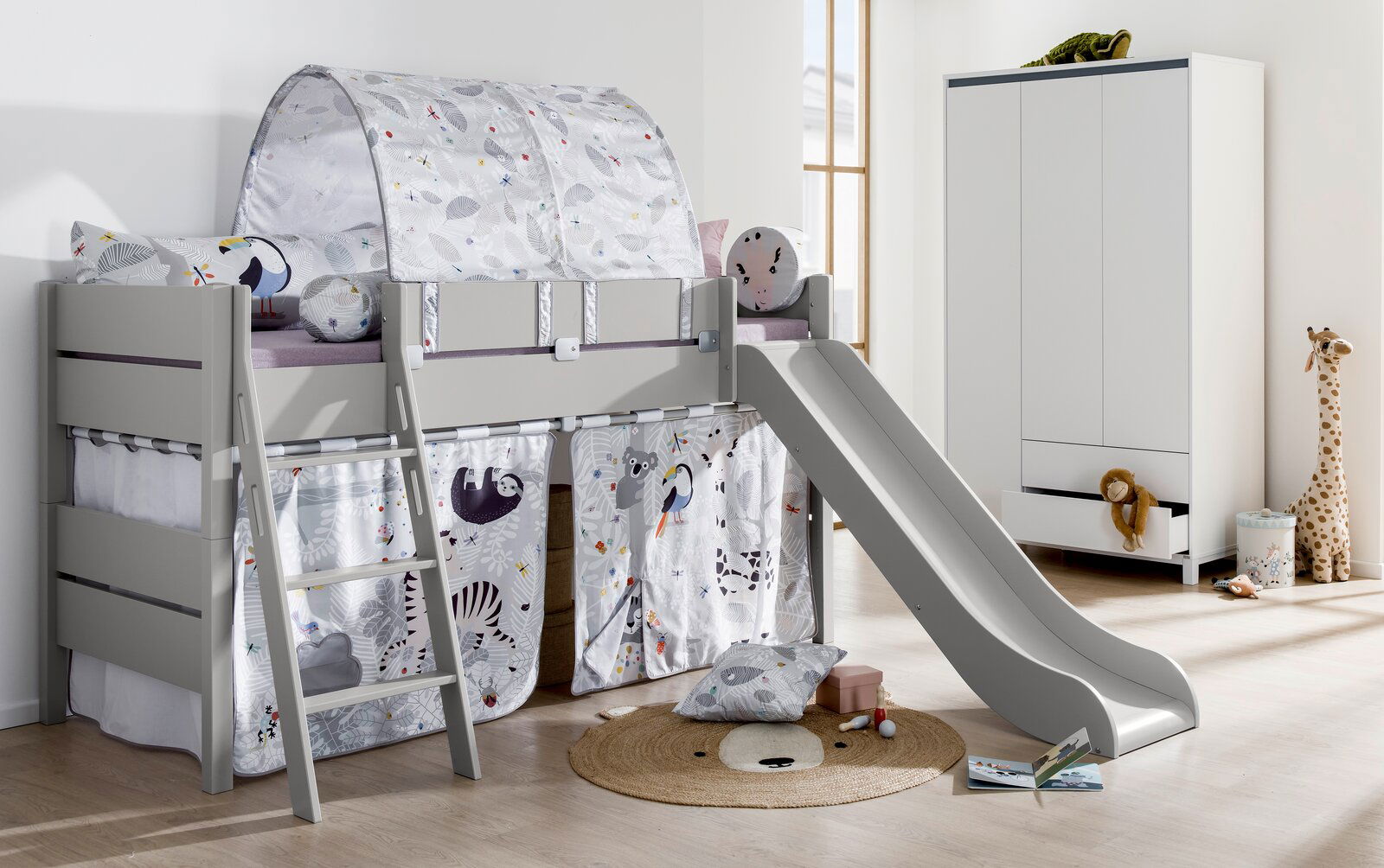 Spielbett mit Rutsche und Leiter, dekoriert mit Tiermotiven, aus seitlicher Perspektive fotografiert.
