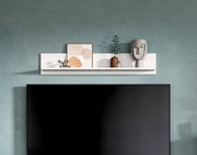 Weißes, schwebendes Wandregal über einem großen Flachbildfernseher an blaugrüner Wand, dekoriert mit gerahmtem Bild, Glasvase mit Zweig und grauer Skulptur; Frontalansicht.