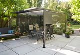 Moderne Pergola mit Faltdach und Sichtschutz in einem sonnigen Garten, seitliche Perspektive