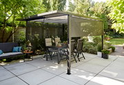 Moderne Pergola mit Faltdach und Sichtschutz in einem sonnigen Garten, seitliche Perspektive