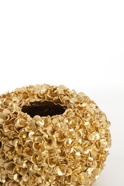 Goldene Vase mit blütenartiger Struktur, von oben betrachtet.