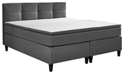 Graues Boxspringbett mit gepolstertem Kopfteil, seitliche Perspektive