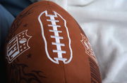 Nahaufnahme eines NFL Konturenkissens in Form eines Footballs mit sichtbarem NFL-Logo und weißen Nähten.