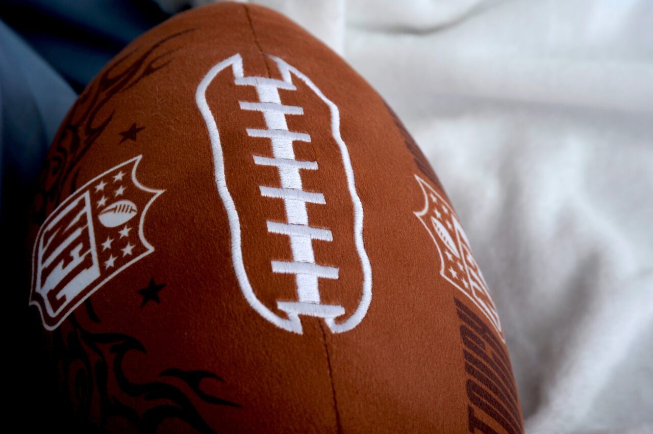 Nahaufnahme eines NFL Konturenkissens in Form eines Footballs mit sichtbarem NFL-Logo und weißen Nähten.