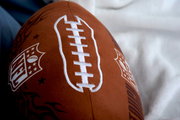 Nahaufnahme eines NFL Konturenkissens in Form eines Footballs mit sichtbarem NFL-Logo und weißen Nähten.