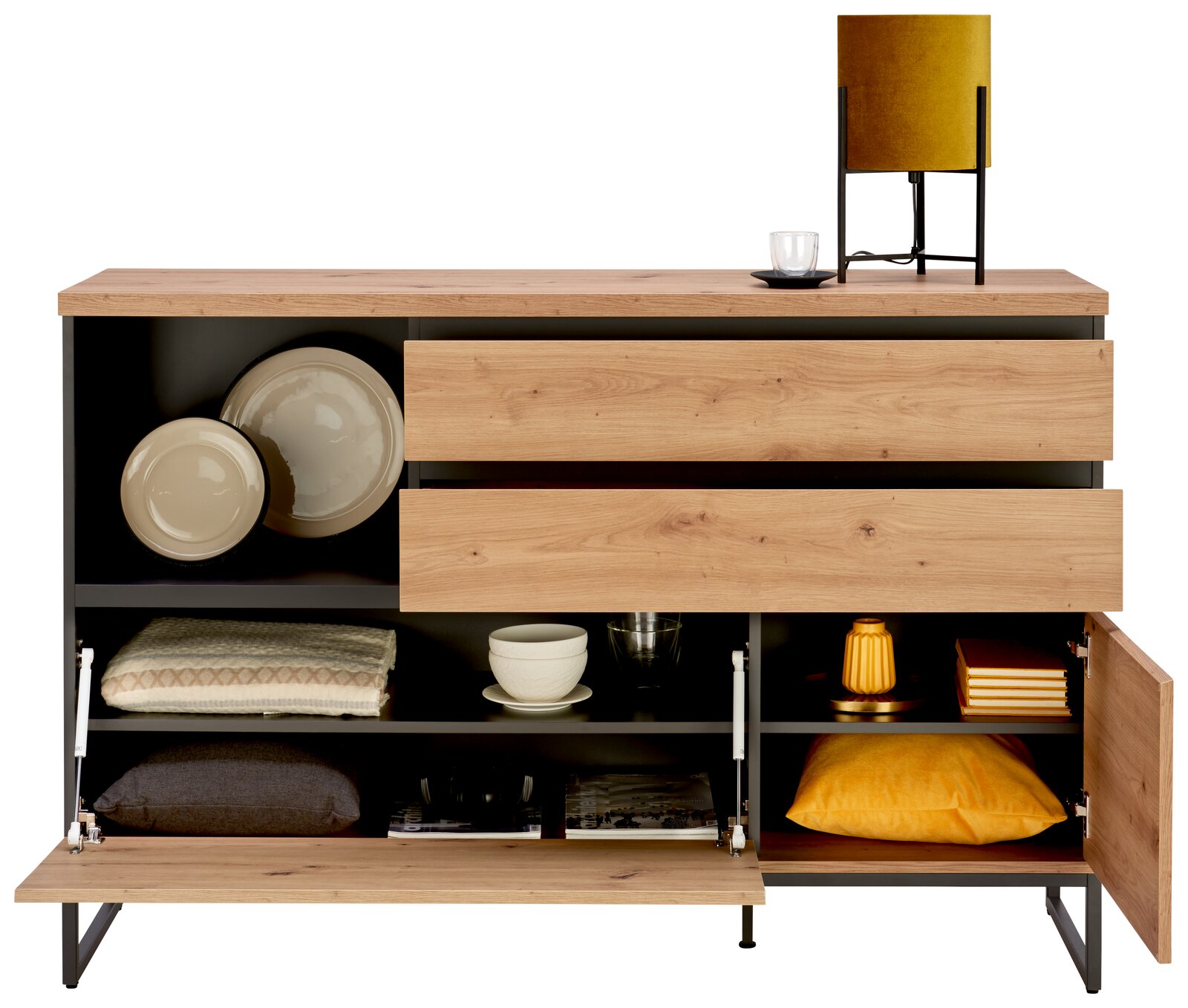 Kommode aus Holz mit offenen Schubladen und Fächern, gefüllt mit Geschirr, Textilien und Dekorationen, aus frontaler Perspektive.