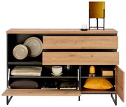 Kommode aus Holz mit offenen Schubladen und Fächern, gefüllt mit Geschirr, Textilien und Dekorationen, aus frontaler Perspektive.