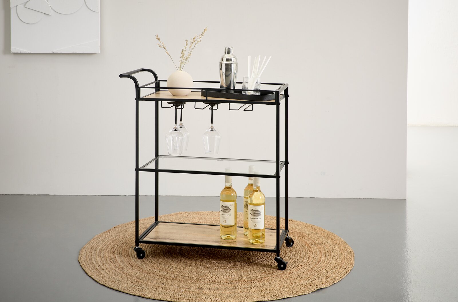 Schwarzer Barwagen/Servierwagen aus Metall mit Holzablagen und Glasboden, mit hängenden Weingläsern und Flaschen, auf Rollen – Frontansicht in leicht schräger Perspektive.