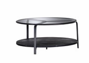 Moderner Couchtisch mit Glasplatte und schwarzem Metallgestell, seitliche Perspektive