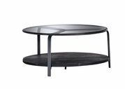 Moderner Couchtisch mit Glasplatte und schwarzem Metallgestell, seitliche Perspektive