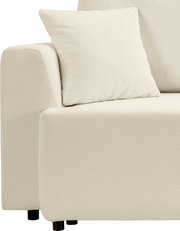 Beiges Polstersofa mit Armlehne und Zierkissen, Detailansicht aus seitlicher Frontperspektive