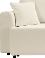 Beiges Polstersofa mit Armlehne und Zierkissen, Detailansicht aus seitlicher Frontperspektive