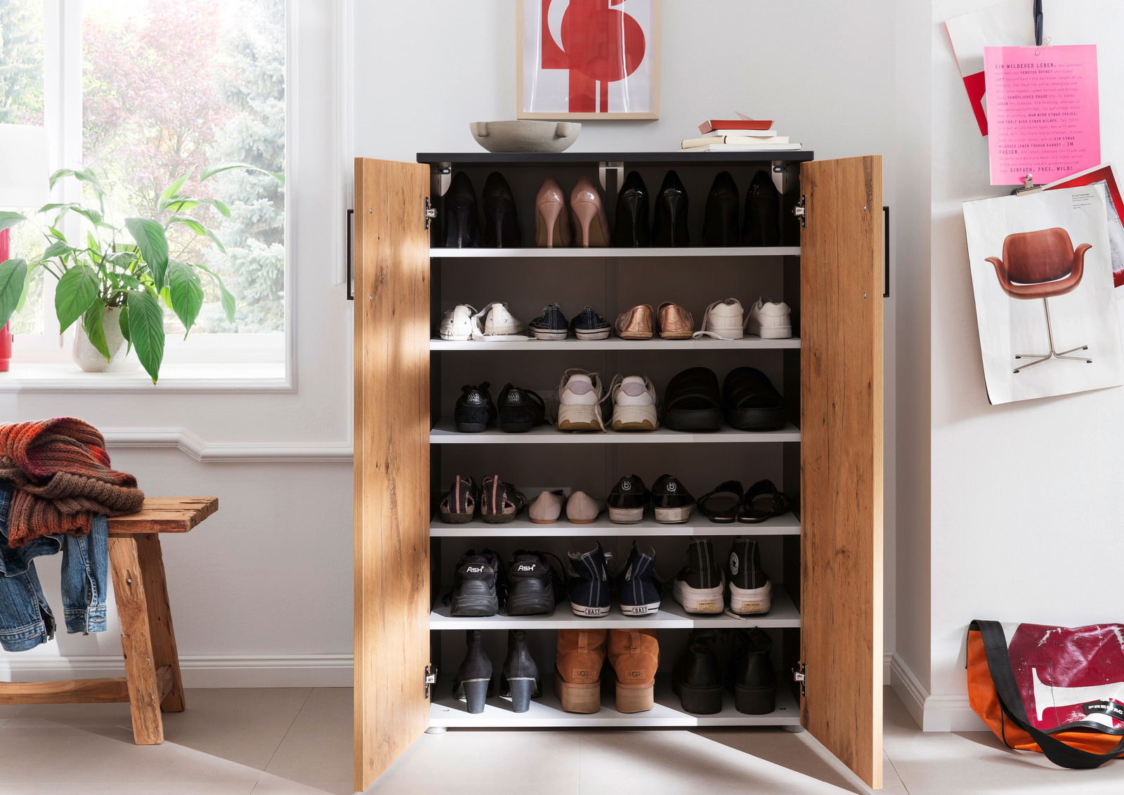 Schuhschrank mit offenen Türen, gefüllt mit verschiedenen Schuhen, aus der Frontalperspektive fotografiert.