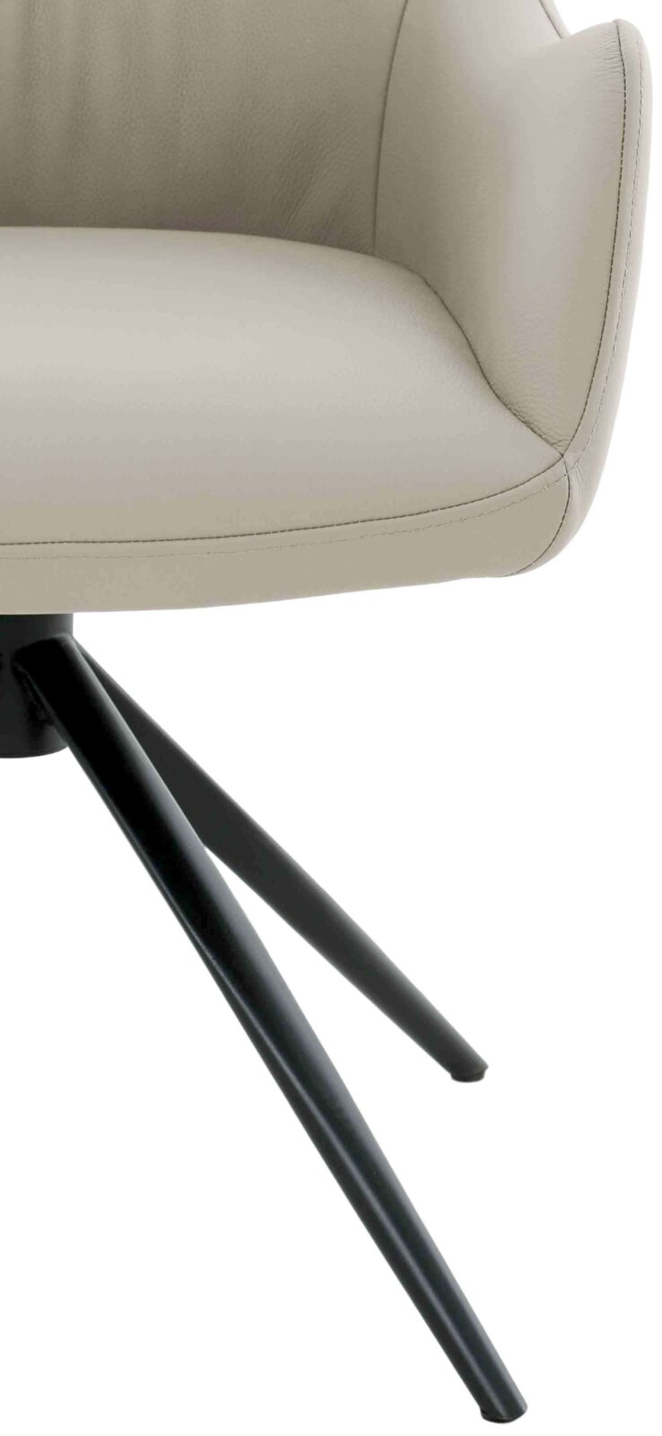 Close-up van een moderne fauteuil met beige lederen bekleding en zwarte metalen poten, gezien vanaf de zijkant