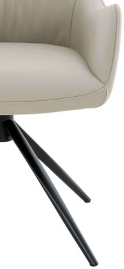 Close-up van een moderne fauteuil met beige lederen bekleding en zwarte metalen poten, gezien vanaf de zijkant