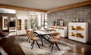 Moderne Wohnzimmermöbel in einem stilvollen Raum mit Esstisch, Stühlen und beleuchteten Highboards, seitliche Perspektive.
