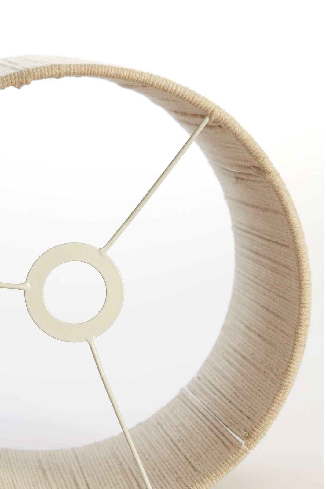 Nahaufnahme eines beigen Lampenschirms mit sichtbarer Metallstruktur von innen.